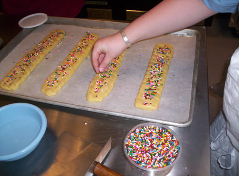 Dropping colored sprinkles on paximadhia dough